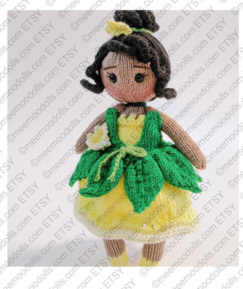 a little doll that is sitting on a blanket 